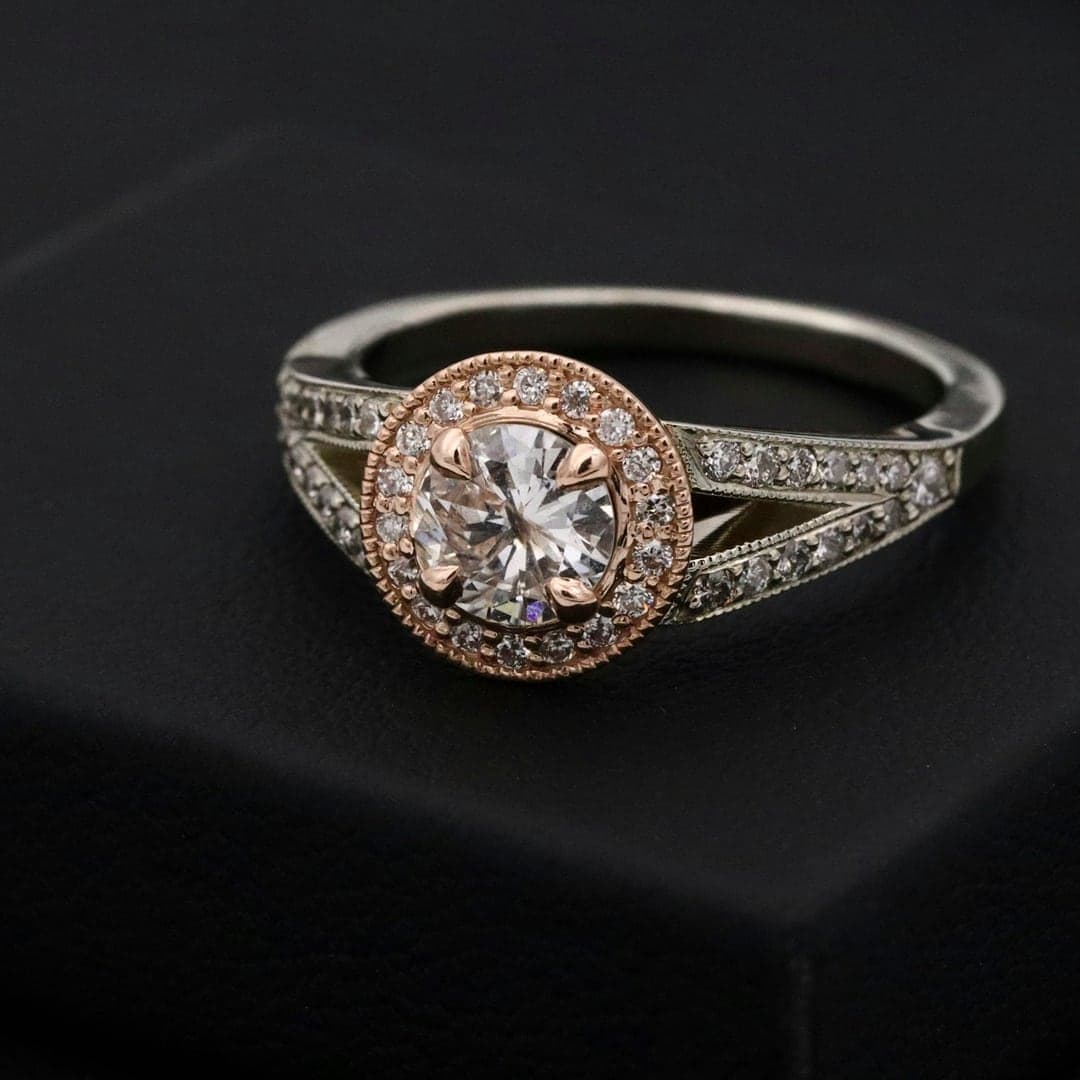 Diamond halo ring with a split pavé shank displayed on a black box