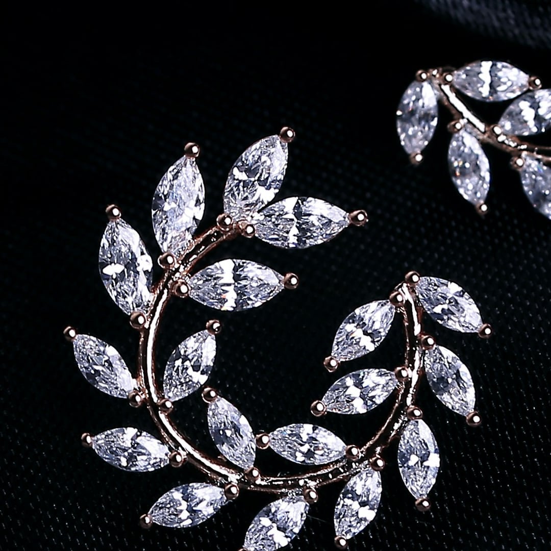 Close-up detail — laurel wreath earrings set with marquise diamonds on black velvet